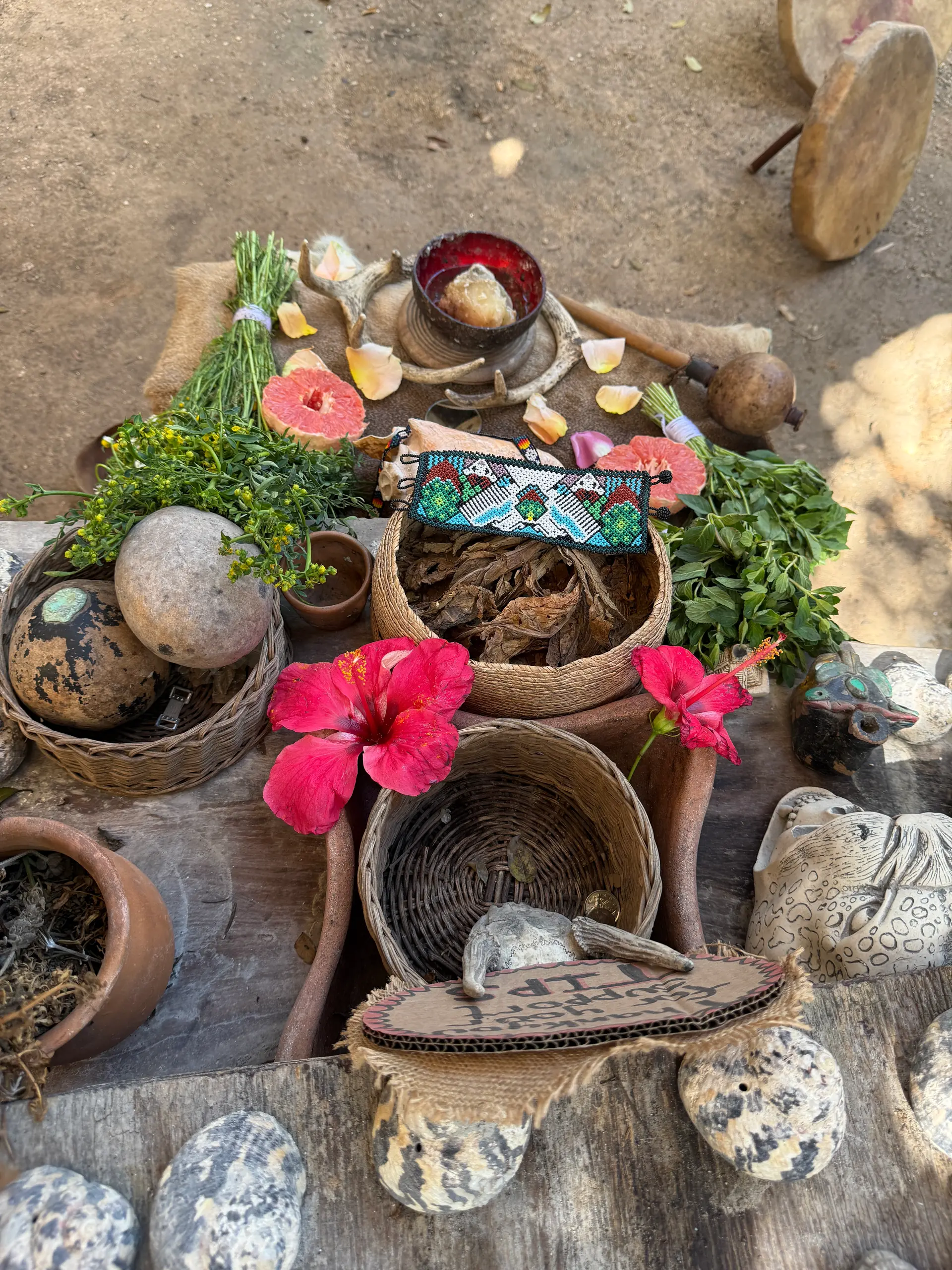 Un autel avec des fleurs d’hibiscus, des paniers, des calebasses et du copal
