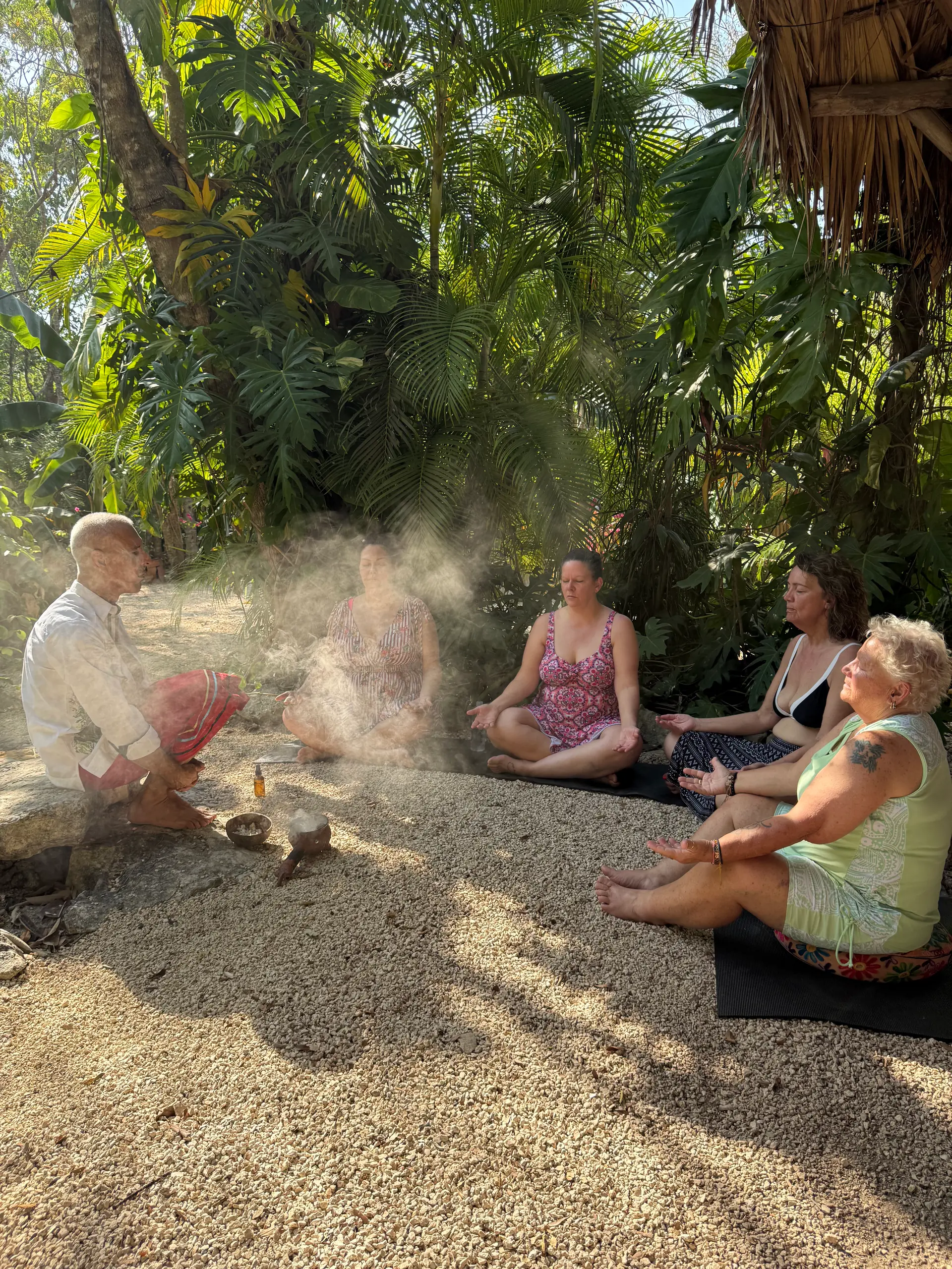 Le cercle assis dans la jungle tandis que la fumée de copal monte à contre-jour