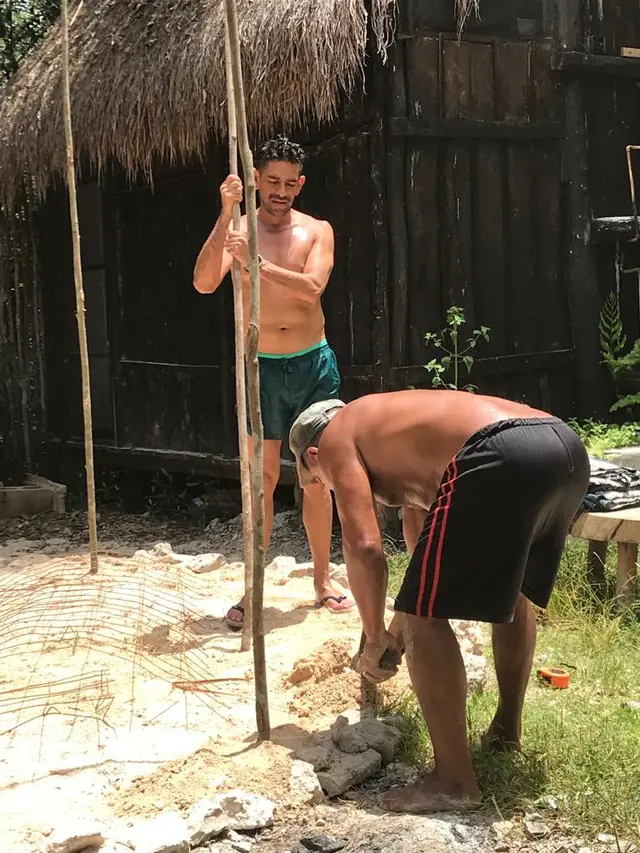 Two people setting the poles and laying out the foundation of the temazcal