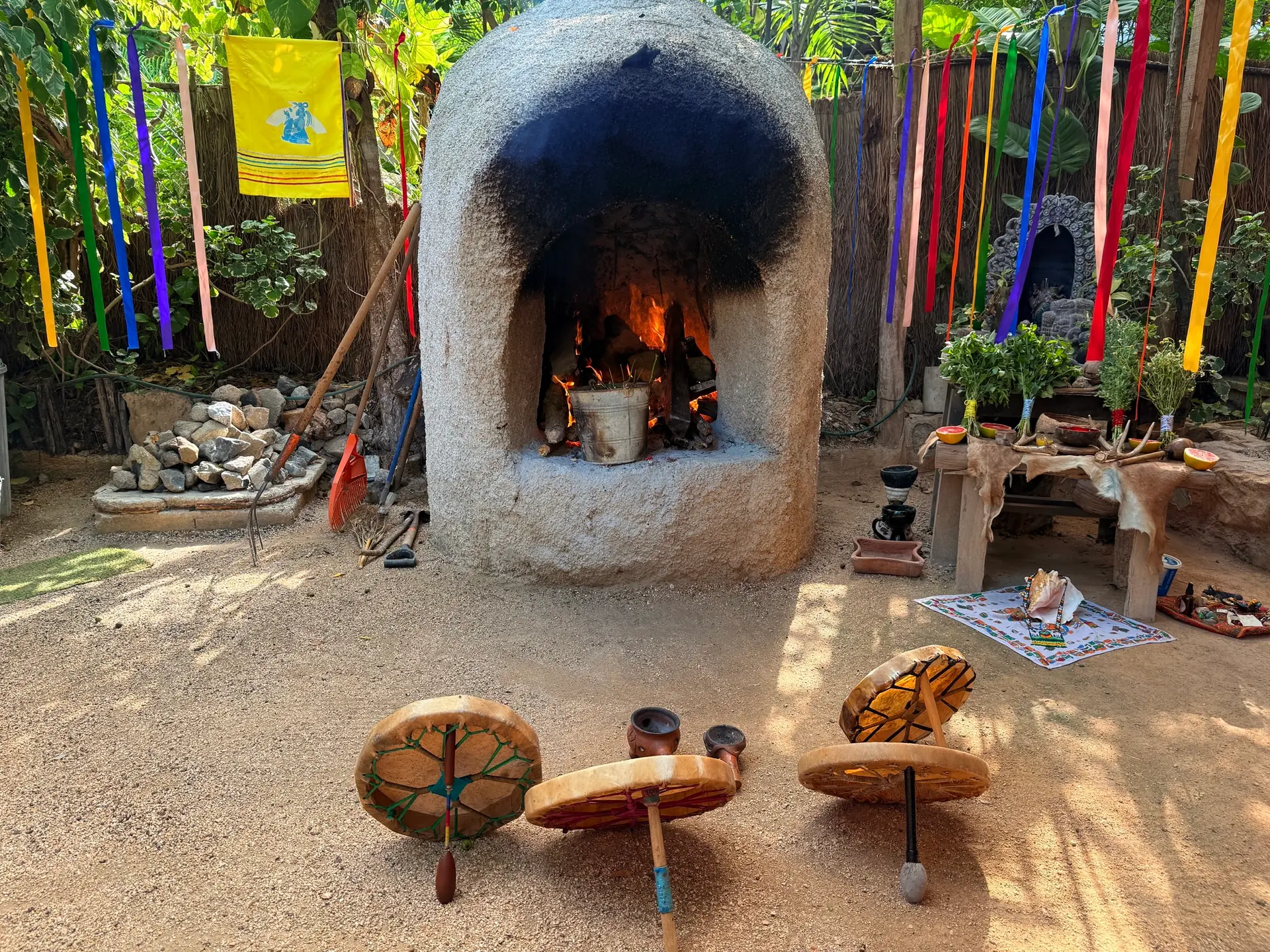 El fuego ardiendo dentro del horno de piedra, con el altar y los tambores preparados