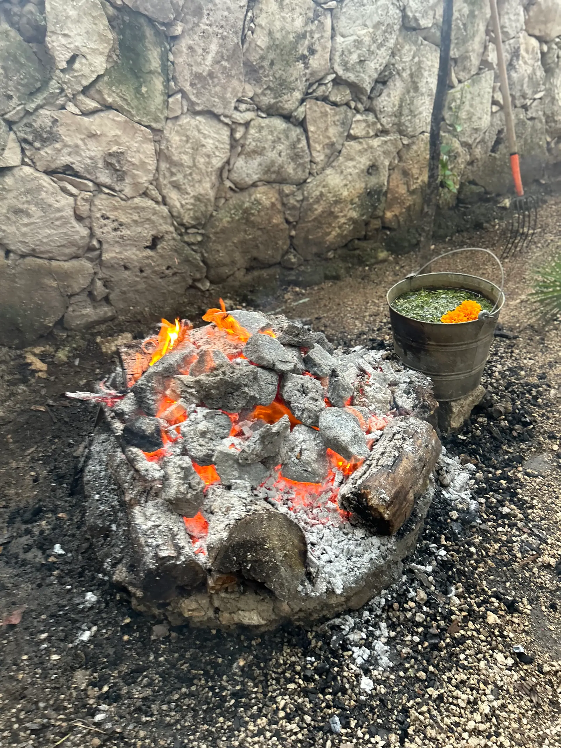 Las piedras volcánicas calentándose sobre las brasas, horas antes de la ceremonia