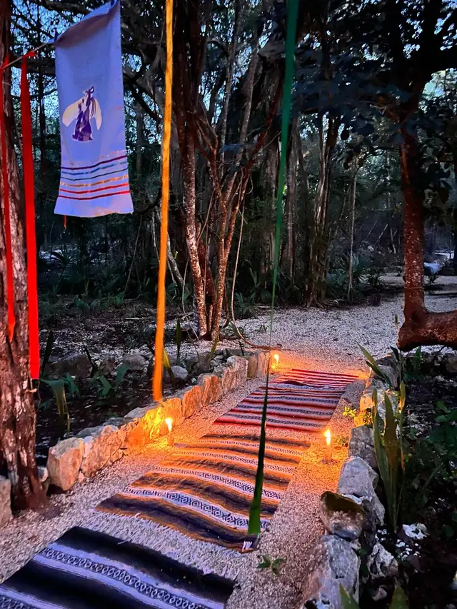 El sendero de tapetes y velas al anochecer, entre listones de colores y el estandarte